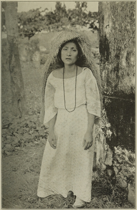 WOMAN OF THE BATAN ISLANDS WITH GRASS HOOD.